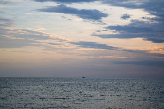 Scenic view of calm sea horizon under sunset sky with clouds