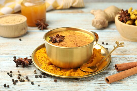 Golden milk turmeric latte and ingredients old wooden table, closeup