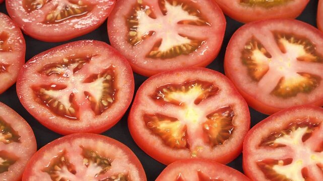 Macro detail of a ripe red tomato slice cross section revealing juicy seeds and texture.