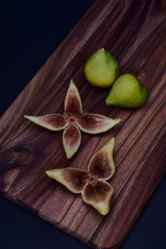 Fresh green figs whole and sliced on a wooden serving board