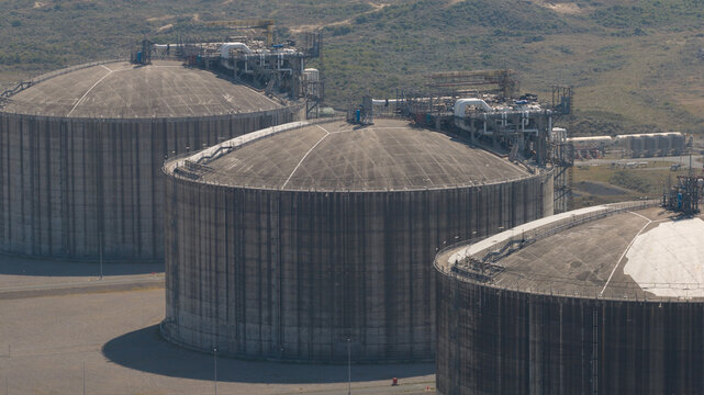 Aerial view of the Dunkirk LNG Terminal featuring large concrete storage tanks and industrial infrastructure in Loon-Plage, Hauts-de-France, France.