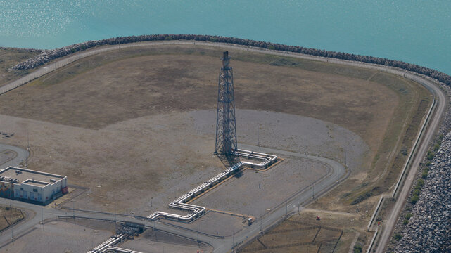 Aerial view of the Dunkirk LNG Terminal featuring a prominent flare stack, industrial pipelines, and surrounding coastal infrastructure in Loon-Plage, Hauts-de-France, France.