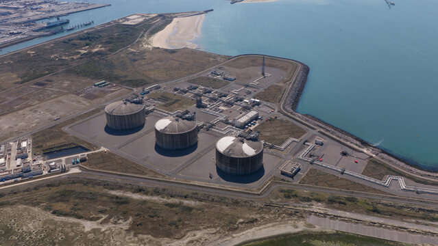 Aerial view of Dunkirk LNG Terminal featuring large storage tanks, industrial infrastructure, and pipelines situated along the coastline in Loon-Plage, Hauts-de-France, France.
