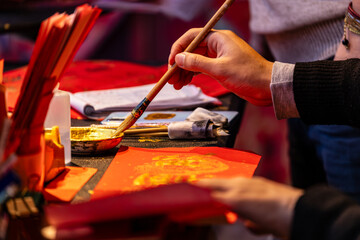 Fototapeta premium Hands Writing Chinese Calligraphy for Lunar New Year