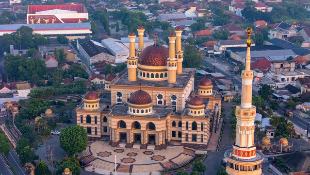 Aerial view of the Great Mosque of Klaten with its prominent domes and minaret, surrounded by the urban landscape of Klaten, Central Java, Indonesia.