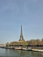 Fototapeta premium A wide daytime view of the Eiffel Tower in Paris, France, standing tall under a clear blue sky