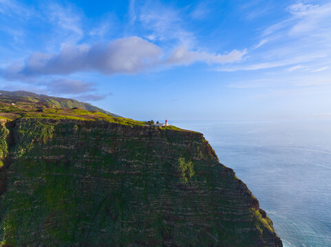 Aerial view of the Ponta do Pargo Lighthouse perched on a dramatic green cliff overlooking the Atlantic Ocean in Madeira, Madeira, Portugal.