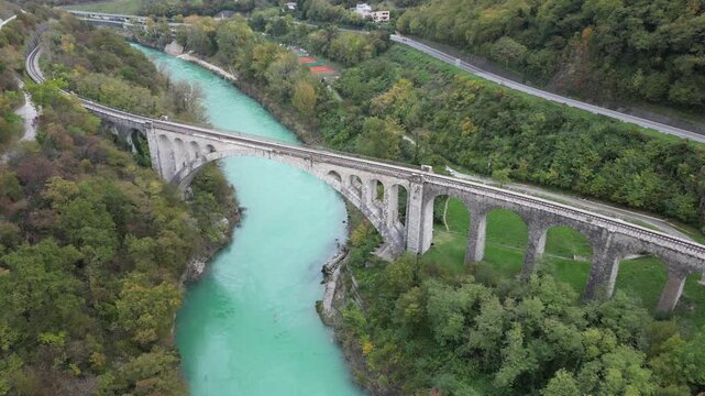 Stunning aerial footage of the iconic Solkan Bridge, an impressive stone arch railway viaduct spanning the beautiful turquoise Soca River in Slovenia