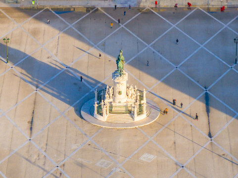 Aerial view of the statue of King Jose I in the center of the Praca do Comercio square with geometric paving and people walking in Lisbon, Lisbon, Portugal.