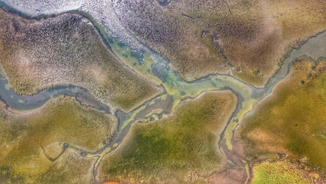 Aerial view of the historic salt pans at Solana Ston, featuring intricate geometric water channels and textured salt flats in Ston, Dubrovacko-neretvanska, Croatia.