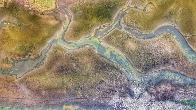 Aerial view of the historic salt pans at Solana Ston, featuring intricate patterns of shallow water basins and earthen embankments in Ston, Dubrovacko-neretvanska, Croatia.