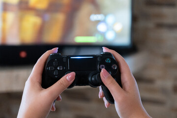 Gamer holding a video game controller while playing at home, close-up gaming and entertainment concept © Iryna