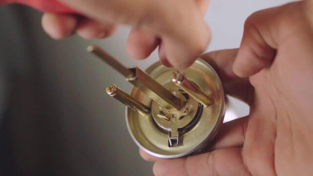 Professional locksmith assembling door handle mechanism with screwdriver