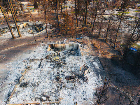 Aerial view of the aftermath of the Spokane wildfire, showing charred trees and the ruins of a destroyed home covered in white ash in Spokane, Washington, United States.
