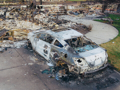 Aerial view of a burnt car and debris from the Spokane wildfire in a residential area in Spokane, Washington, United States.