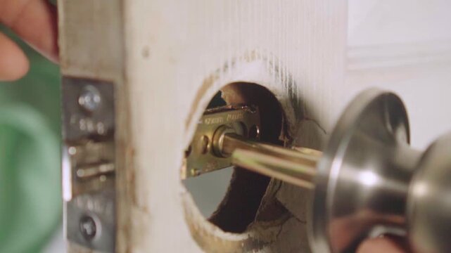 Handyman repairing and installing a new door lock