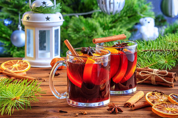 Obraz premium Christmas mulled red wine glühwine with aromatic spices and citrus fruits on a wooden rustic table, close-up. Traditional hot drink at Christmas or New Year time