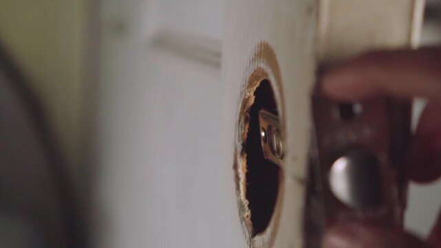 Handyman repairing a broken door latch mechanism