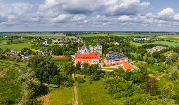 Aerial view of the historic Cistercian Abbey in Lad, with its red-roofed buildings set amidst lush green fields and trees in the rural landscape of Lad, Greater Poland Voivodeship, Poland.