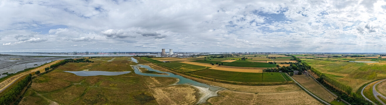 Aerial view of the Doel Nuclear Power Plant surrounded by agricultural fields, wetlands, and the Scheldt river in Beveren-Kruibeke-Zwijndrecht, Vlaanderen, Belgium.