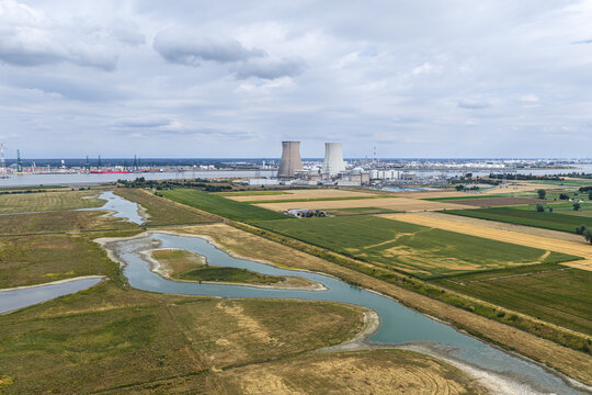 Aerial view of Doel Nuclear Power Plant with cooling towers near the Scheldt river, surrounded by agricultural fields and wetlands in Beveren-Kruibeke-Zwijndrecht, Vlaanderen, Belgium.