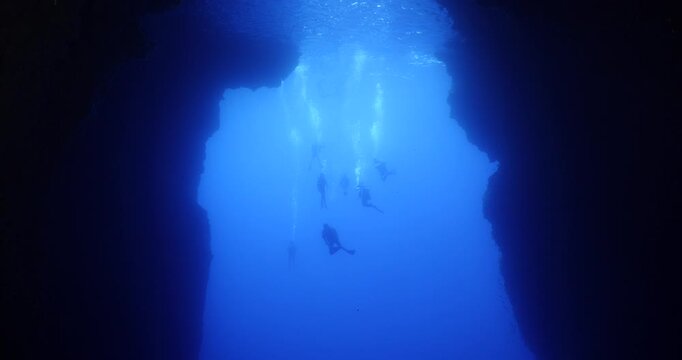 scuba divers are starting a cave dive underwater