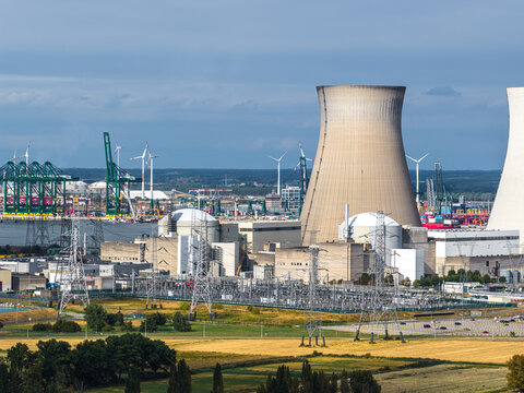 Aerial view of Doel Nuclear Power Station with cooling towers, electrical substation, and industrial port infrastructure in the background, Beveren, Vlaanderen, Belgium.