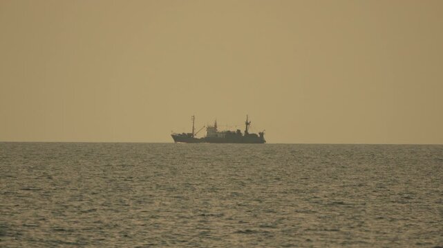 Ship ocean seascape, large vessel sailing on vast open sea under a hazy golden sky, tranquil journey