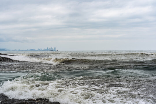 Black Sea waves with city skyline on the horizon in Poti, Georgia