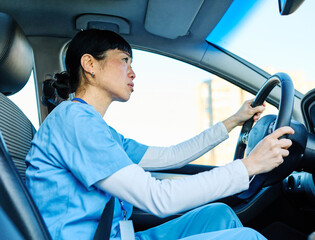 Fototapeta na wymiar Female nurse sitting in car, going home from work. Female doctor driving car to work, on-call duty.