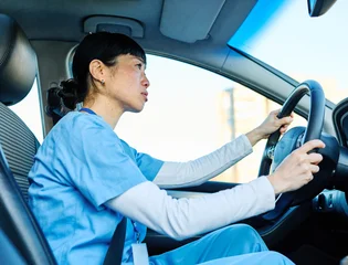 Female nurse sitting in car, going home from work. Female doctor driving car to work, on-call duty. © Lumos sp