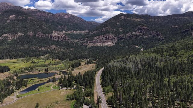 Aerial of mountain valley with lake and forest in Colorado on Wolf Creek Pass with dense coniferous forests covering steep canyon walls on highway 160 in summer