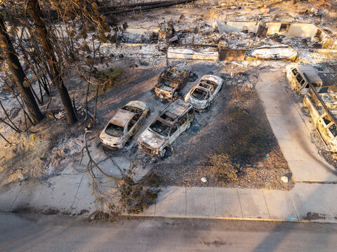 Aerial view of wildfire damage showing scorched trees and destroyed vehicles in a residential neighborhood in Spokane, Washington, United States.