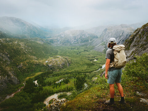 Man with backpack hiking solo in Norway explore Rago park mountains travel healthy lifestyle endurance eco tourism freedom active adventure summer vacation trip survival outdoor traveler enjoying view