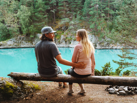 Couple in love sitting on log talking together travel camping together romantic vacations weekend, family relationship lifestyle man and woman friends enjoying nature river and forest, bonding moments