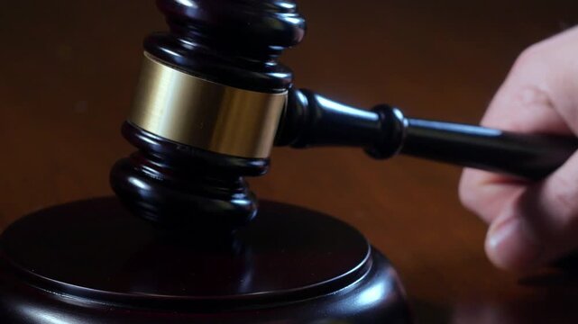 Judge hammering gavel onto sounding block close up 4k video