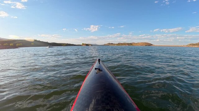 Immersive POV kayaking across Horsetooth Reservoir in Fort Collins, Colorado - summer scenery as a carbon fiber kayak cuts through boat-driven waves, surrounded by the scenic foothills