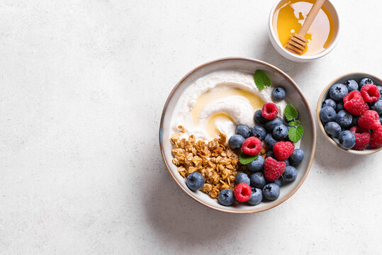 Granola bowl with greek yogurt, berries and honey for healthy breakfast.