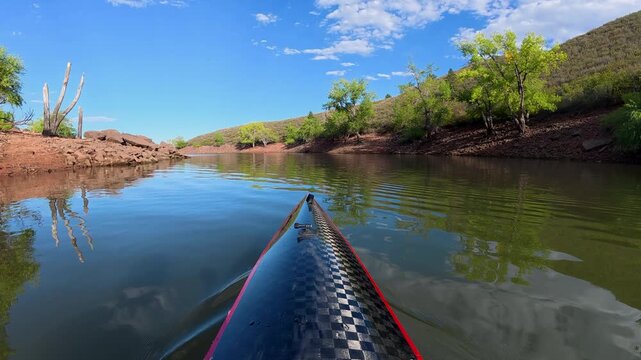 Immersive POV kayaking across Horsetooth Reservoir in Fort Collins, Colorado - summer scenery as a carbon fiber kayak glides on a calm water, surrounded by the scenic foothills of the Rocky Mountains 