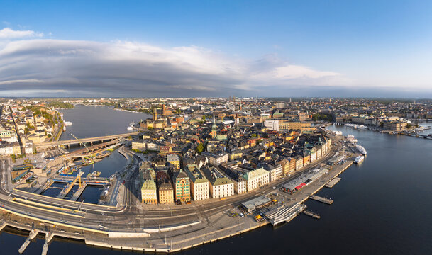 Aerial view of Gamla stan in Stockholm, featuring historic colorful buildings, narrow streets, waterfront quays, and bridges under a clear blue sky in Stockholm, Stockholm County, Sweden.