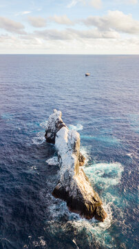 Aerial view of Roca Partida surrounded by deep blue ocean waters with a small boat nearby in Mexico.