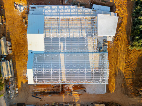 Aerial view of a construction site featuring a large metal frame structure under development in Chania, Greece.