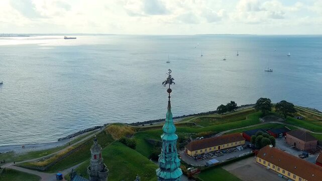 Helsingor, Denmark. Kronborg Castle, a 16th-century Renaissance fortress with copper spires and sandstone walls, Drone footage over the Oresund Strait. Drone footage, Departure of the camera