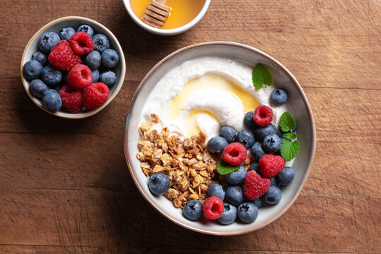 Granola bowl with greek yogurt, berries and honey for healthy breakfast.
