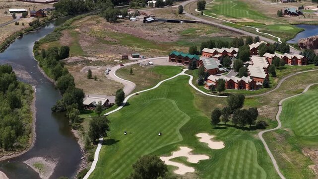 Aerial of luxury golf resort and lodge in South Fork Colorado along Rio Grande River with manicured green fairways in summer