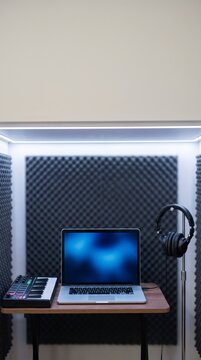 Soundproof recording studio booth with a laptop template and a midi keyboard