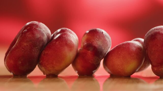 Nectarine or peach fruit, fresh Spanish red nectarine, peaches stacked on wooden table with red background