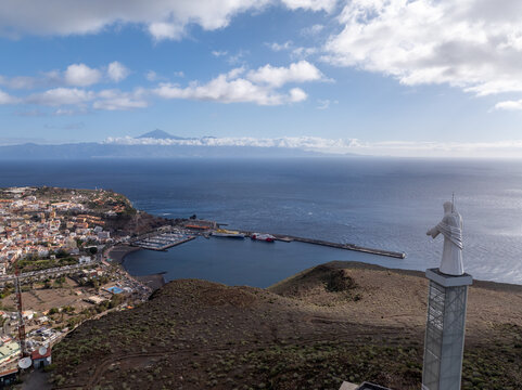 Aerial view of the Sagrado Corazon de Jesus statue overlooking the port of Santa Cruz de La Palma with the island of Tenerife visible across the Atlantic Ocean in the Canary Islands, Spain.