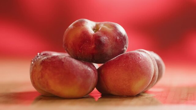 Nectarine or peach fruit, fresh Spanish red nectarine, peaches stacked on wooden table with red background