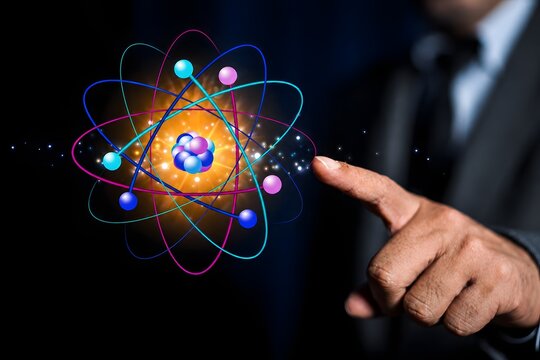 Businessman finger pointing creative atom on blue background. Nuclear fusion concept, endless energy, cheap electricity, future technologies. Science and future concept